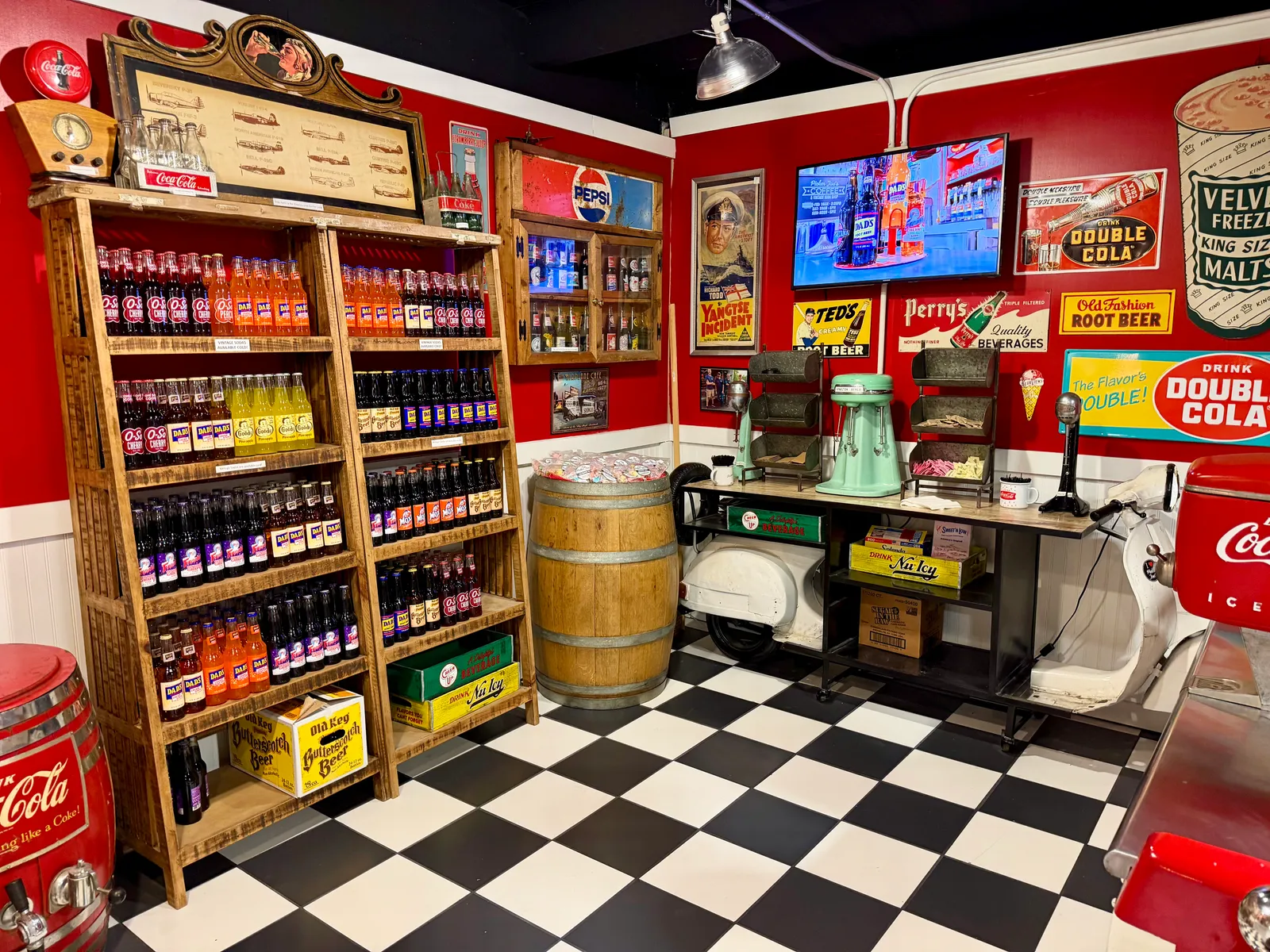 A wall of vintage soda bottles over a black-and-white checkerboard floor